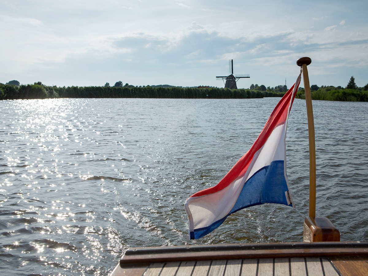 Foto vanuit een boot met wapperende vlag op het Alkmaardermeer